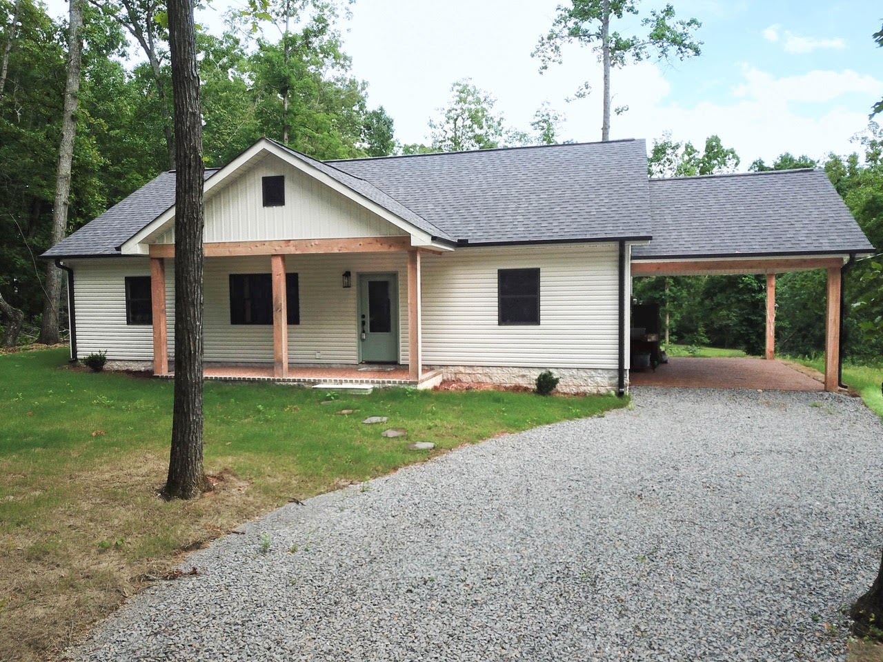 Front exterior of 10 County Road 665, showing the covered porch and carport